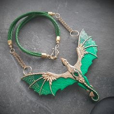 This marvelous green dragon necklace is totally handmade of polymer clay. It is decorated with fancy filigree, glossy enamels and shiny green cabochon. It can become a perfect gift for a fantasy lover or Ren Faire goer. A must have dragon lover gift. Bib width 4 3/4  inches Bib height 3 1/3 inches Necklace length 19 inches Please feel free to contact me if you need a customization. Dragon Choker Necklace, Polymer Clay Dragon Pendant, Dragoncore Aesthetic Outfits, Dragon Clay, Dragon Gifts, Dragon Lover, Dragon Necklace, Dragon Jewelry, Green Dragon