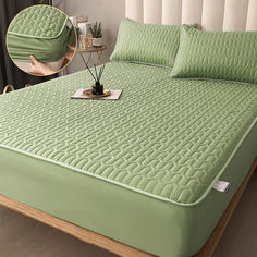 a bed with green sheets and pillows on it