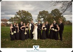 a bride and groom with their bridal party in the grass at an outdoor wedding