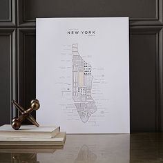 the new york city map is displayed next to some books on a table with a pair of scissors