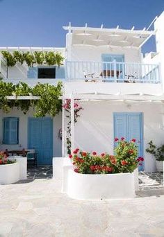 a white house with blue shutters and flowers