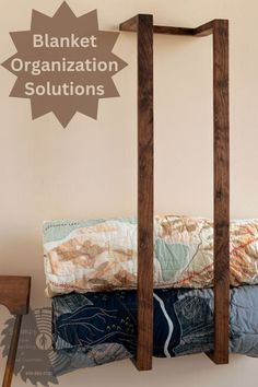 there is a wooden rack with clothes on it and the words blanket organization solutions above it