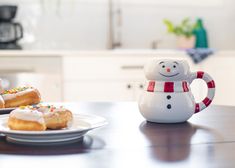 two donuts with frosting and sprinkles on them sitting on a table