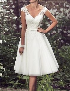 a woman in a white dress posing for the camera