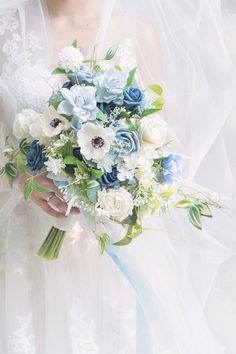 a bride holding a bouquet of blue and white flowers