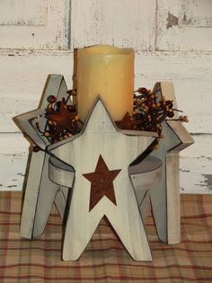 a white wooden star next to a lit candle