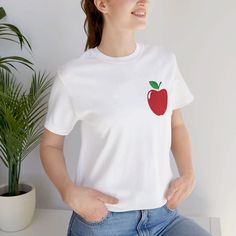 With its clean lines and simple aesthetic, this design captures the essence of minimalism while showcasing the beauty of a classic fruit.  This classic unisex jersey short sleeve tee fits like a well-loved favorite. Soft cotton and quality print make users fall in love with it over and over again. These t-shirts have-ribbed knit collars to bolster shaping. The shoulders are tapered for a better fit over time. Dual side seams hold the garment's shape for longer. .: Made with 100% Airlume combed and ring-spun cotton, a lightweight fabric (4.2 oz/yd² (142 g/m that is easy to layer, breathable. Perfect for active and leisure wear.  .: The retail fit that is perfect for casual and semi-formal settings. The crew neckline adds a classic, neat style that's perfect for accessorizing. .: Bella+Canva Apple Tshirt, Fruit Shirt, Simple Aesthetic, Neat Style, Prism Color, Red Apple, Leisure Wear, Jersey Shorts, Lightweight Fabric