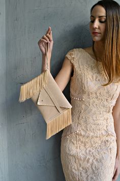 "Small Medusa Clutch in sand beige. An adorable leather clutch with fringes for beautiful fashion looks. This envelope clutch is ideal to carry anything you might need! A handmade wrislet from Italian genuine suede leather in sand beige colour and silk fringes. The interior is fully lined with beige leatherette. It closes with one metal rivet stud in silver or gold. The pictures show the clutch with silver stud. The clutch comes with a removable wrist strap made from the same leather. Dimensions Elegant Evening Bag With Fringe, Beige Envelope Clutch For Evening, Fringed Clutch Evening Bag, Fringe Clutch Evening Bag, Fringed Evening Clutch Bag, Elegant Clutch With Fringe, Chic Fringe Clutch For Parties, Elegant Fringe Clutch Evening Bag, Elegant Fringed Clutch Evening Bag