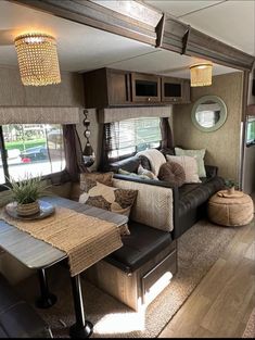 a living area with couches, tables and windows in a recreational vehicle or rv