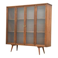 a wooden bookcase with glass doors and two shelves on one side, against a white background