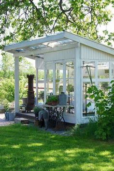 a small white house sitting under a tree