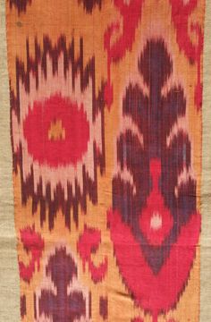 an old rug with red and yellow designs on it