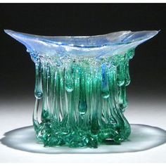 a green glass vase sitting on top of a table