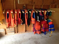 there are many umbrellas hanging on the rack in this room and one is orange