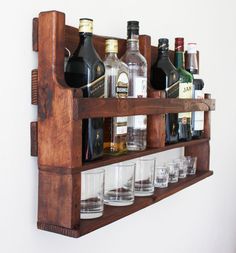 a wooden shelf filled with lots of bottles and glasses on top of eachother