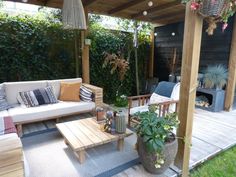 an outdoor living area with wooden furniture and plants