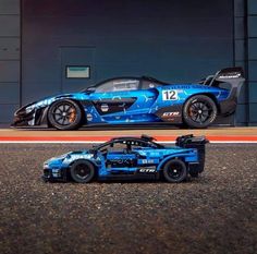 a blue race car parked in front of a garage