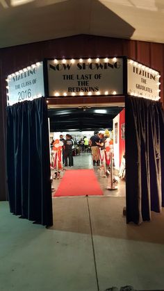 an entrance to a show with lights on the sides and red carpeted flooring