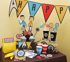 a birthday party table with cupcakes and decorations