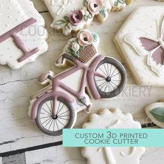 some decorated cookies with flowers and a bicycle on them are sitting next to each other