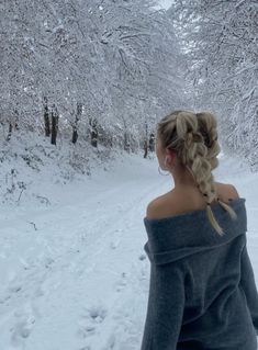 a woman standing in the snow with her back to the camera