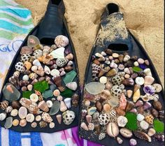 there are two boats made out of seashells and shells on the beach towel