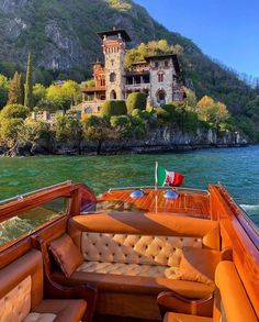 the inside of a boat that is in the water near a large house on top of a hill