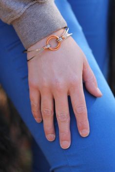 Skill Level: Beginner Time Required to Complete: 20 minutes Supplies Needed: 2 - 12 gauge 15mm ID Jump Rings 2 feet - 20 gauge Copper Wire 2 feet - 14 gauge Square Stainless Steel Wire 1 - Hook Clasp Make this stunning and distinctive piece of wearable art. Here's the tutorial for our Stainless Steel and Copper Focal Bangle. The bracelet is eye catching, comfortable to wear and offers the jewelry maker the opportunity to make something unusual. This tutorial contains clear color photos and easy Adjustable Copper Jewelry In Wearable Art Style, Handmade Modern Copper Jewelry, Modern Handmade Copper Jewelry, Adjustable Nickel-free Jewelry In Wearable Art Style, Modern Adjustable Jewelry With Soldered Detail, Silver Circle Earrings, Oxidized Silver Earrings, 12 Gauge, Pretty Bracelets