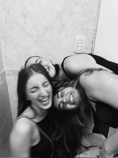 three women are posing in the bathroom together