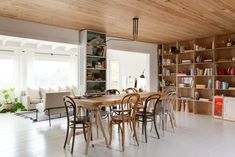 a dining room table with chairs and bookshelves