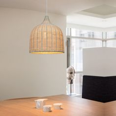 a wooden table sitting in front of a window with a lamp hanging above it and two cups on the table