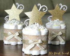 three diaper cakes with gold stars on top