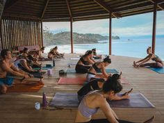 a group of people doing yoga on the beach