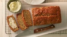 a loaf of bread sitting on top of a cutting board next to butter and a knife