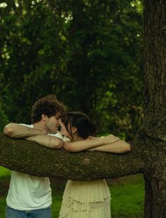 two people standing next to each other on a tree branch