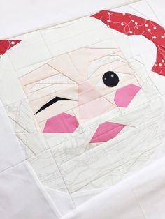 a close up of a piece of fabric with a santa face on it and a red hat