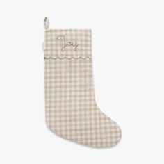 a christmas stocking with the word joy written on it and a gingham check pattern