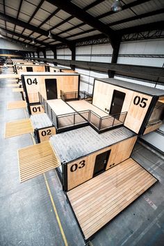 several wooden boxes are lined up in an empty warehouse with numbers on the doors and floor