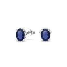 pair of earrings with blue sapphire stones in white gold and diamonds on the sides, set against