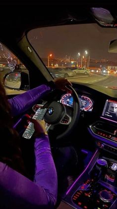 a woman driving a car at night on the highway with her hands on the steering wheel