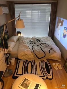 a bed room with a neatly made bed and pictures on the wall