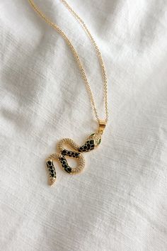 Flat lay view of the Lucia Black & Gold Snake Necklace which features gold chain link single layer with a black and gold snake medallion Cobra Necklace, Gold Snake Necklace, Expensive Jewelry Luxury, Snake Pendant, Snake Necklace, Jewelry Luxury, Expensive Jewelry, Gold Snake, Black And Gold