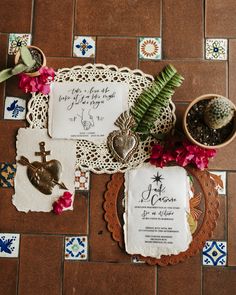 the wedding stationery is laid out on the floor next to some succulents