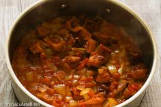 a pot filled with meat and vegetables on top of a wooden table