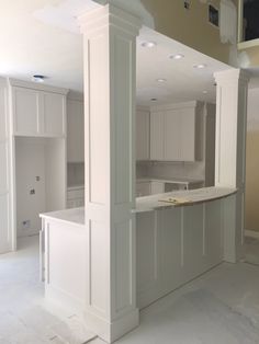 an empty kitchen is shown with white cabinets and counter tops in the middle of the room