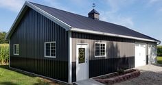 a black and white garage with two doors on the front, and one door open to let in light