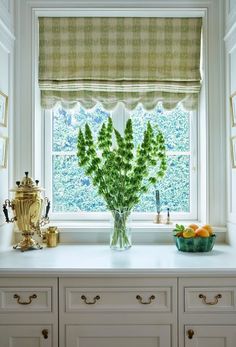 a vase with some flowers in it sitting on a window sill