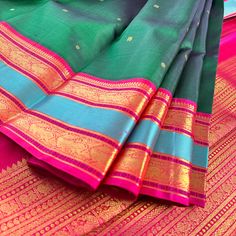 Introducing this magnificent handwoven korvai kanjivaram silk saree, adorned with buttis in rich emerald green body and deep pink contrast beautifully in the border and pallu, accentuated by a rama blue woven band and traditional gold zari motifs. Experience a perfect blend of traditional Indian artistry and modern elegance. Approximate Length 6.5 mtrs (inclusive of blouse length) Approximate Height - 48 - 52" Approximate weight - 1.7 lbs Saree comes with fall, picot and tassels done when applic Multicolor Paithani Silk Saree With Tilla, Multicolor Paithani Silk Saree With Tilla Details, Green Saree With Border In Traditional Drape, Green Art Silk Dupatta With Tilla Detail, Green Tilla Art Silk Dupatta, Green Traditional Wear With Border For Festivals, Green Banarasi Silk Dupatta With Tilla, Green Saree With Border, Green Saree With Tilla For Traditional Ceremonies