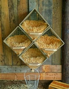 four pans filled with food hanging from the side of a wooden wall next to a wire basket