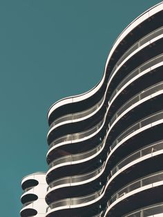 an architectural building with curved balconies against a blue sky